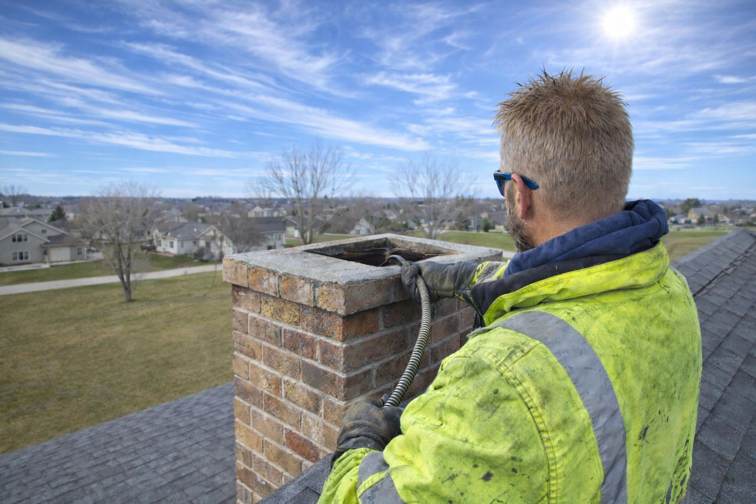 Ike Paxton of Paxton Chimney Sweep, sweeping a Chimney